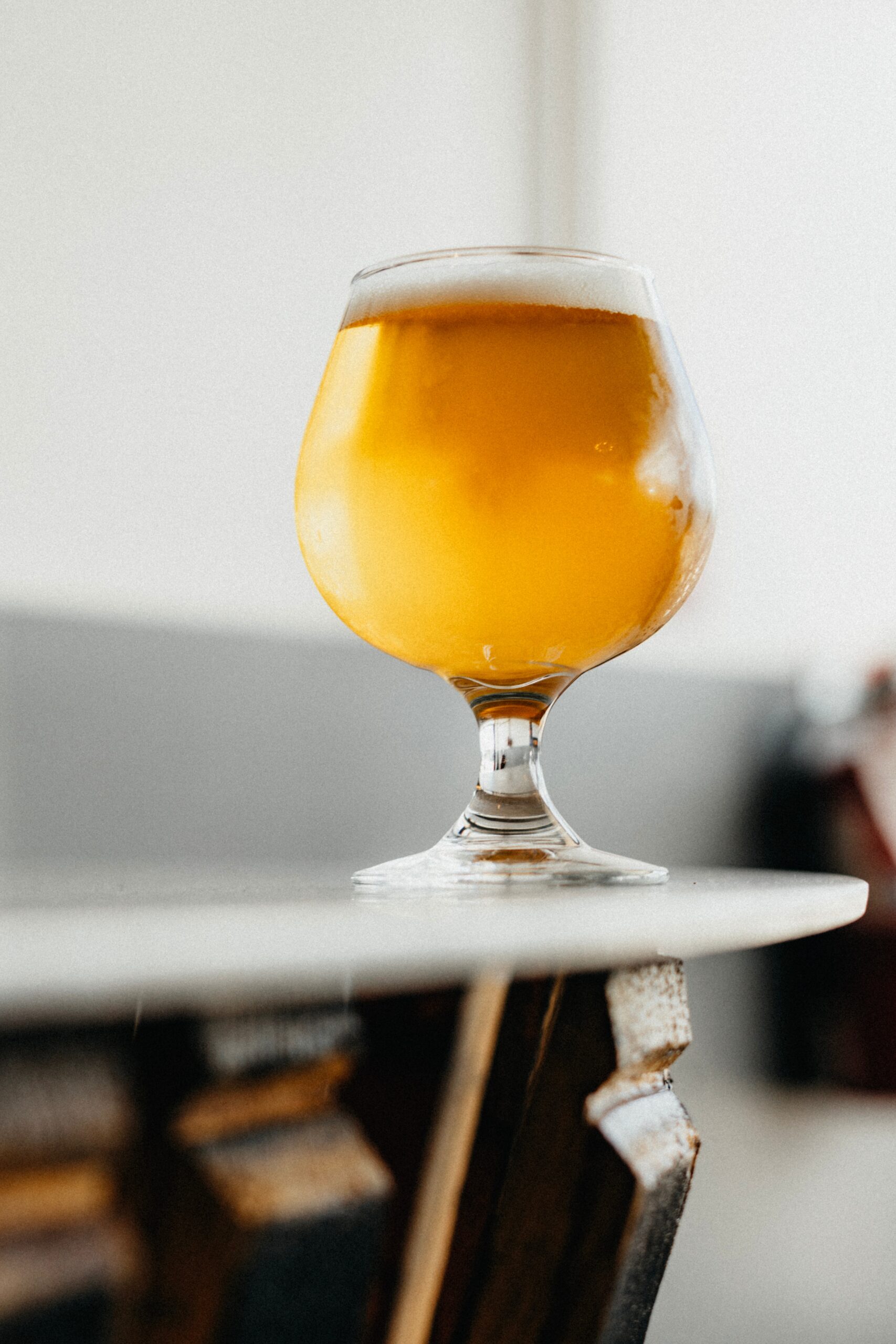 Een Weizen bier op tafel. Het bier heeft een mooie licht gele kleur.